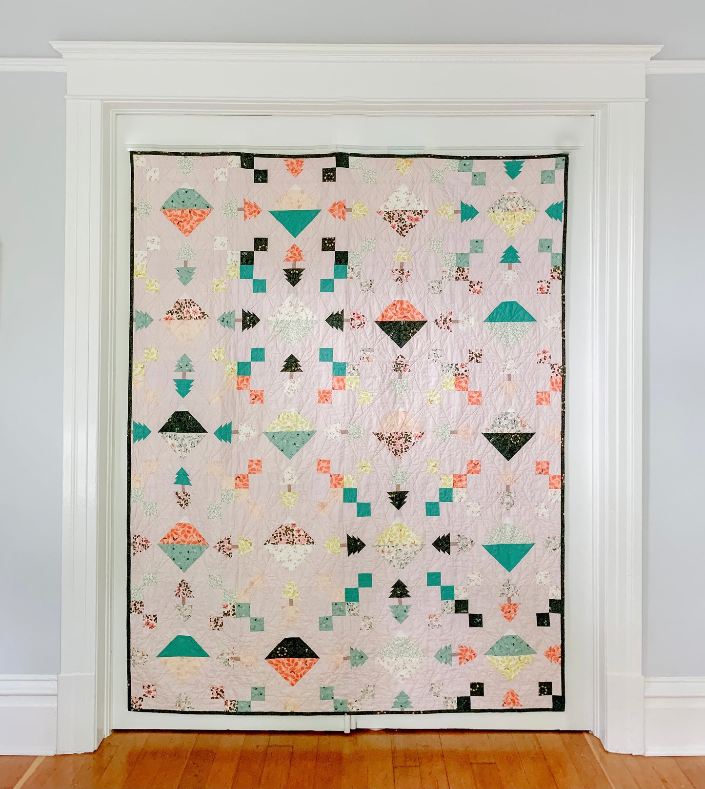 The Highline Quilt Pattern - Julia Wachs Designs - The Highline quilt pattern hung up on a gray wall.