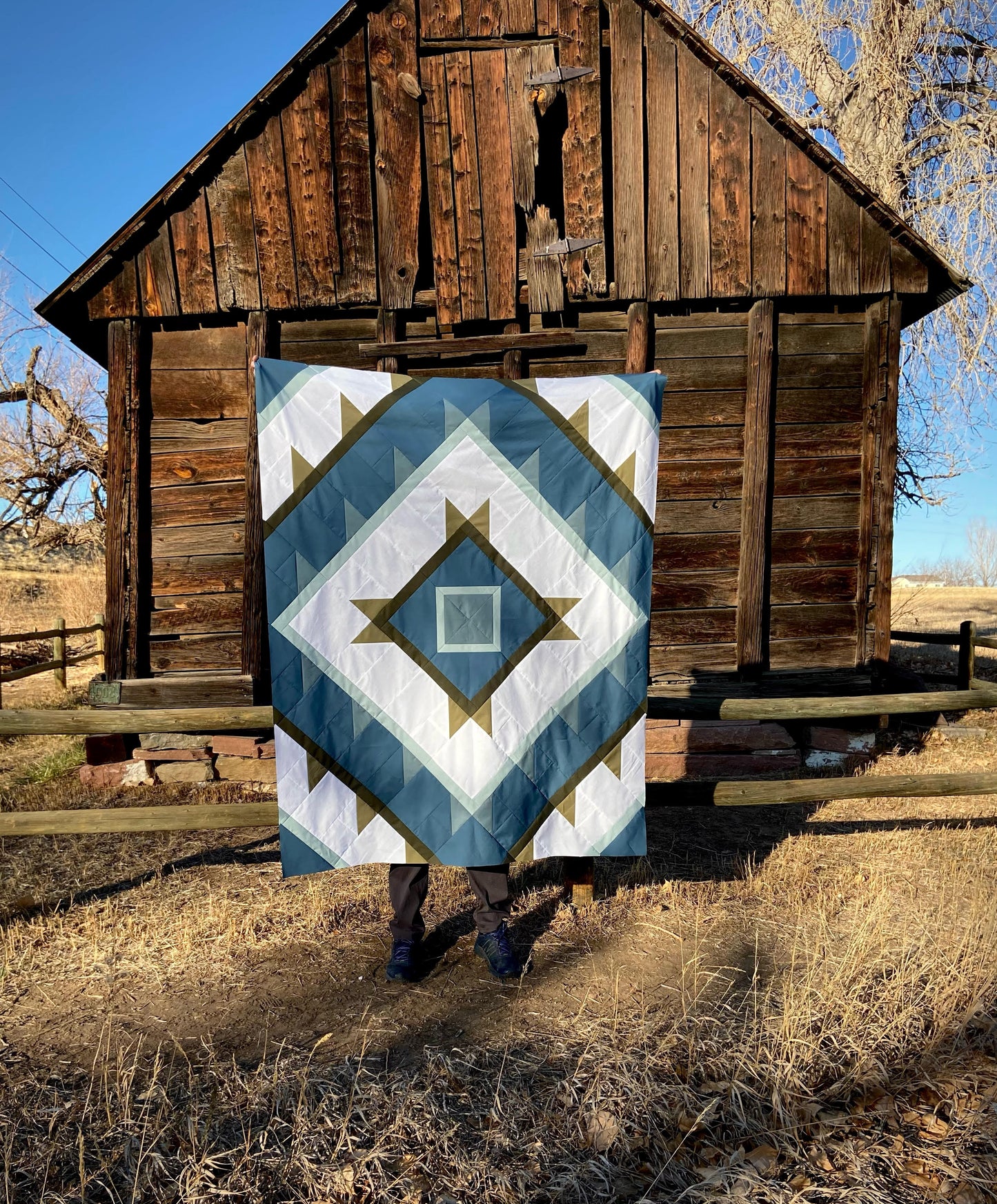 Green Lake Quilt Pattern - Julia Wachs Designs - A teal and white Green Lake quilt pattern in front of a barn.